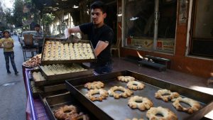 A man arranges sweets to be sold ahead of Ramadan in the rebel-held besieged city of Douma, in the eastern Damascus suburb of Ghouta, Syria.