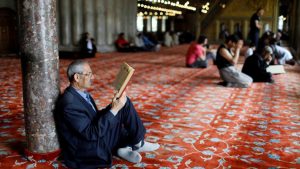 A man reads the Koran in Ottoman-era Sultanahmet Mosque, also known as the Blue Mosque, in Istanbul, Turkey.