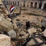 A member of forces loyal to Syria’s President Bashar al-Assad attempts to erect the Syrian national flag inside the Umayyad mosque, in the government-controlled area of Aleppo, during a media tour, Syria, on December 13, 2016.
