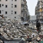 A member of the Syrian government forces stands in a severely damaged street in Aleppo’s newly captured Al-Kalasseh neighbourhood in the eastern part of the war torn city on December 13, 2016.