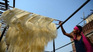 An Indian worker dries vermicelli, a traditional sweet dish, at a factory in Allahabad.