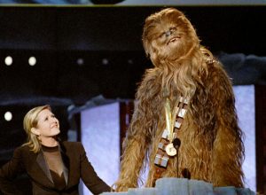 Chewbacca, the eight-foot tall, 200 year-old ‘wookie’ character from ‘Star Wars’, gives his acceptance speech in his own tongue upon receiving the MTV Movie Awards Lifetime Achievement from Carrie Fisher (L), who played Princess Leia Organa in the same movie, on June 7, 1997.