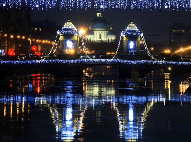 Christmas lights decorate a bridge over the Fontanka River in Saint Petersburg on December 22, 2016.