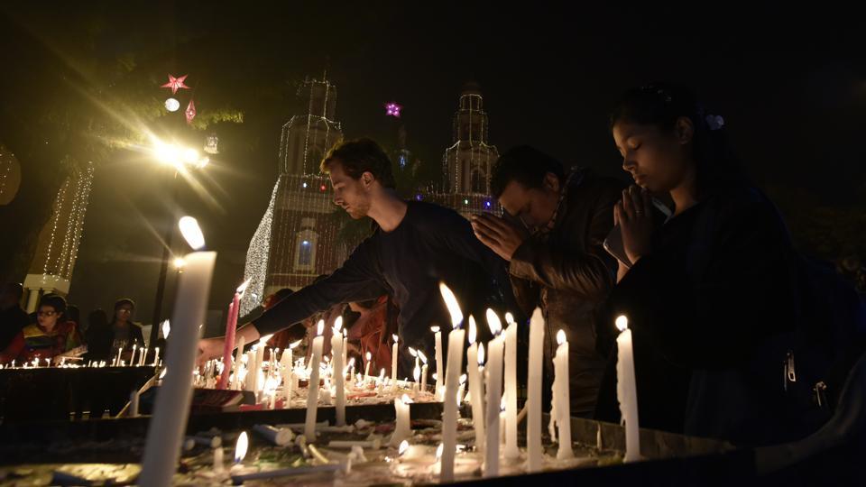 Devotees lights the candles at the Sacred Heart Cathedral on Christmas Eve in New Delhi