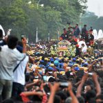 Fans and party workers gather near the MGR Memorial to get a final glimpse of former Tamil Nadu chief minister J. Jayalalithaa as her mortal remains are carried in a proccession to her burial place in Chennai on December 6, 2016. Grief-stricken fans on December 6 mourned the death of one of India’s most popular politicians, Jayalalithaa Jayaram, as fears of unrest loomed in her state where she enjoyed almost god-like status.