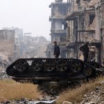 Forces loyal to Syria’s President Bashar al-Assad stand atop a damaged tank near Umayyad mosque, in the government-controlled area of Aleppo, during a media tour, Syria, on December 13, 2016.