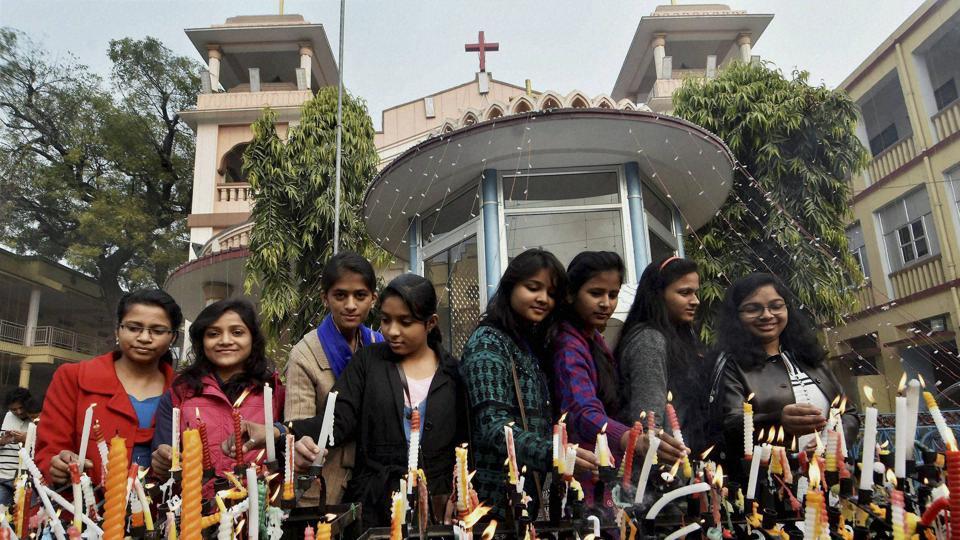 People light candles outside a Church on the occasion of Christmas in Patna