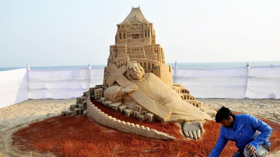 Sand artist Manas Sahoo creates a sand sculpture celebrating Christmas at the beach at Puri in Odisha