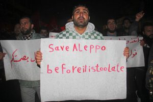 Syrian’s shout slogans during a rally in the rebel-held northwestern city of Idlib, late on December 12, 2016, in support of residents of the rebel-controlled part of Aleppo which is under regime siege.