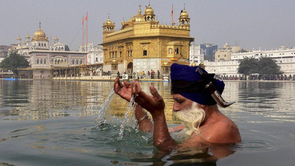A Sikh devotee takes dip in the holy sarovar on the occasion in the Golden Temple premises in Amritsar