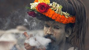 A naga sadhu smokes chillum on the way to Gangasagar mela (festival) at Babughat transit camp in Kolkata, India, on Wednesday, January 11, 2017