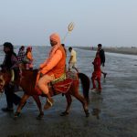 A sadhu rides on a horse to take a holy bath and perform rituals at the Gangasagar Island