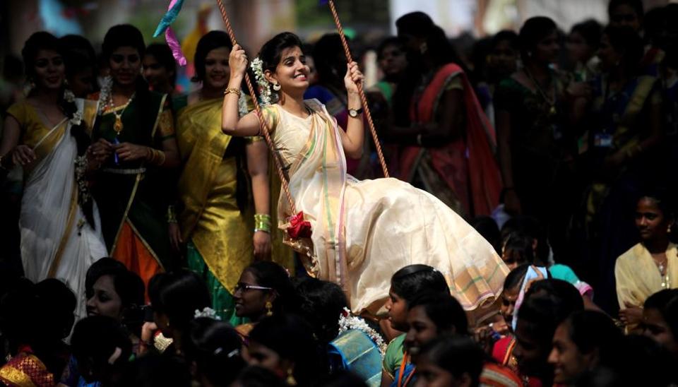 A student plays on a swing during celebrations of the Tamil harvest festival Pongal at a college in Chennai