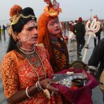 Devotees dressed as Hindu deities collect money from pilgrims at the mouth of the river Ganges on Gangasagar Island