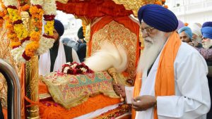 Sikh devotees carry Sri Guru Granth Sahib Ji, the holy book of the Sikh religion, in a special golden palanquin at the Golden Temple during Nagar Kirtan on the eve of 350th birth anniversary of Guru Gobind Singh, Amritsar