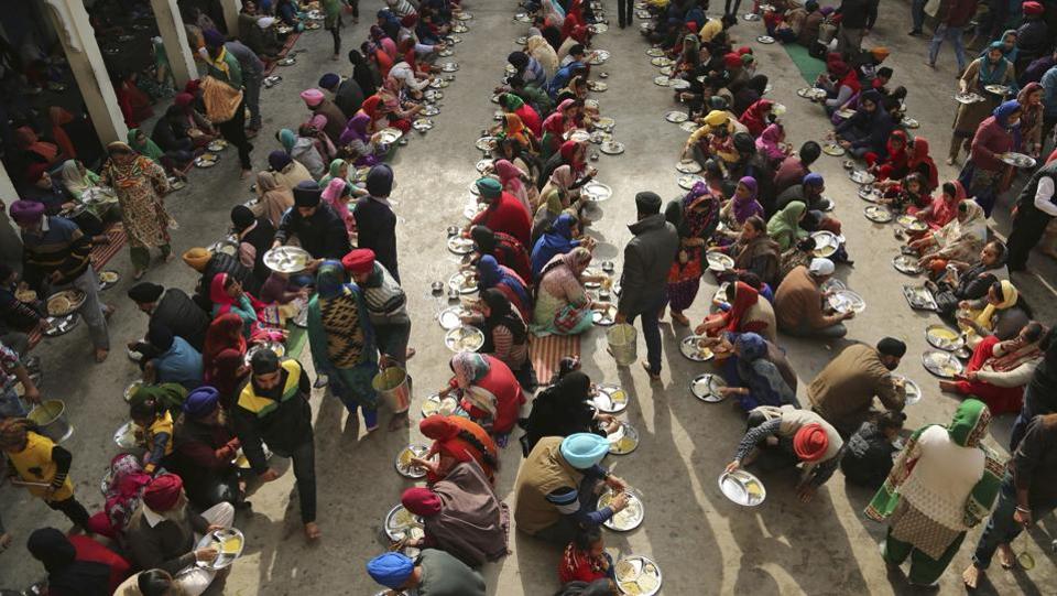 Sikh devotees eat a meal from a community kitchen at a Gurudwara in Jammu, on the birth anniversary of Guru Gobind Singh