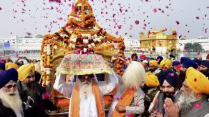 Sikh devotees take part in a procession at the Golden Temple on the eve of the 350th birth anniversary of Guru Gobind Singh in Amritsar