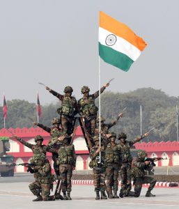 Soldiers hold up the National Flag as they demonstrate combat skills during the 69th Army Day parade in New Delhi