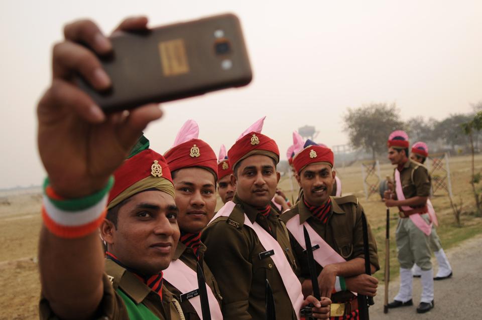 Uttar Pradesh Armed Police personnel click a selfie before taking part in the parade.