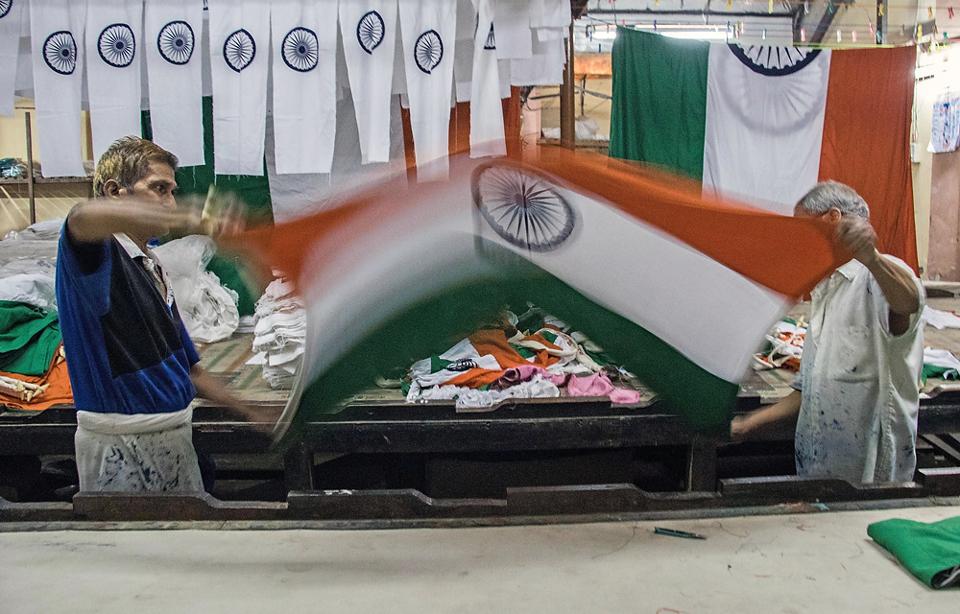 Workers fold the Indian National Flag ahead of Republic Day at Kora Kendra, Borivli