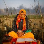 The rituals associated to the Swasthani Katha takes place on the bank of rivers in various Hindu shrines across Nepal. In this picture, a man recite verses from the Swasthani Brata Katha book near the bank of river Saali.