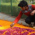 A man preparing a rangoli with flowers at Rose Garden in Chandigarh