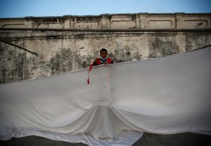 A man work to set up a curtain at the premises of Pashupatinath Temple on the eve of Shivaratri festival in Kathmandu, Nepal February 23, 2017