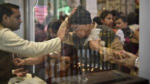 A priest applying tilak on a man’s forehead for good luck