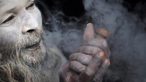 One can view the scenes of Sadhus with their faces smeared with firewood ashes and puffing on cigarettes mixed with marijuana