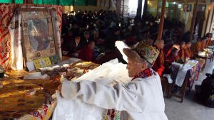 A Tibetan old man offering traditional white Khata (traditional Tibetan scarf) in front of Dalai Lama picture during special Morning Prayer session on the third and one of the most important day of the ‘Losar’