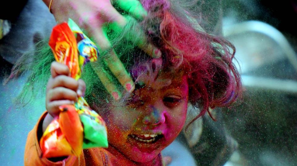 A child plays with gulal during the Holi celebration