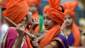 A girl helps another one deck up for a rally in Jogeshwari