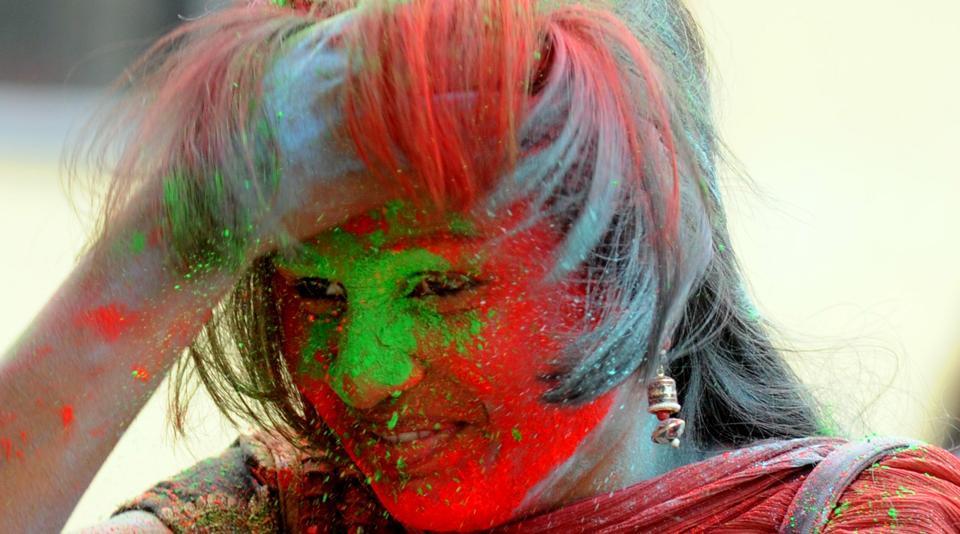 A girl with her face smeared with red colour powder at college campus in Ranchi