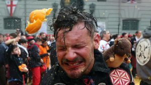 A member of a rival team is hit by an orange during an annual carnival orange battle in the northern Italian town of Ivrea