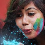 A student blows colour powder during Holi, celebrations inside the university campus in Kolkata, India