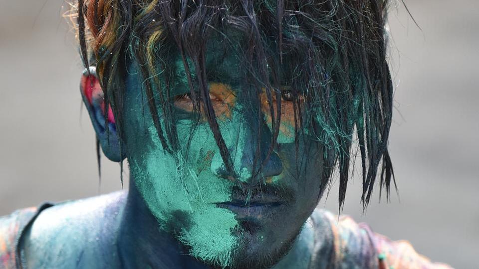 A student with his face smeared in coloured powder, celebrates Holi in Noida. Known as the festival of colors, Holi is celebrated on the last full moon in the lunar month of Phalguna