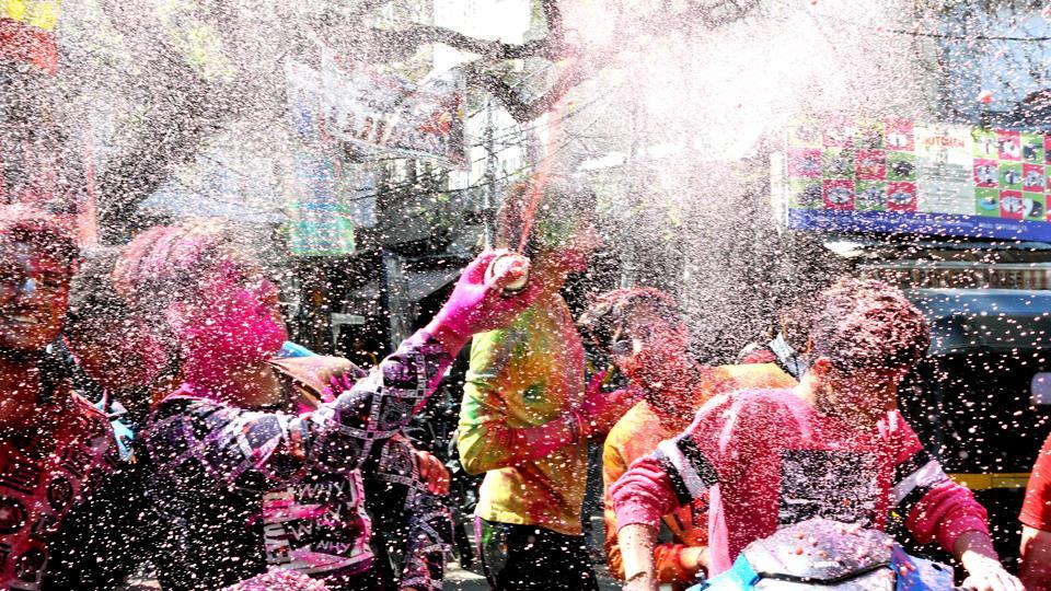 Boys play with coloured water on each other as they celebrate Holi in Jammu