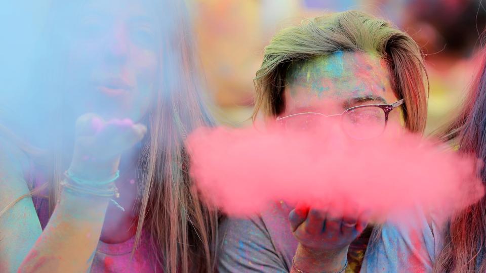 People covered in coloured powder participate in the Indian inspired Holi Festival.