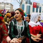 People gesture during a gathering celebrating Newroz, which marks the arrival of spring and the new year, in Istanbul, Turkey