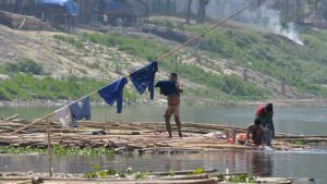 People wash clothes on the banks of the river Brahmaputra in Guwahati on March 21, 2017, on the eve of World Water Day