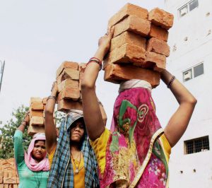 Women carry bricks at a construction site on International Women’s Day in Allahabad on March 8, 2017