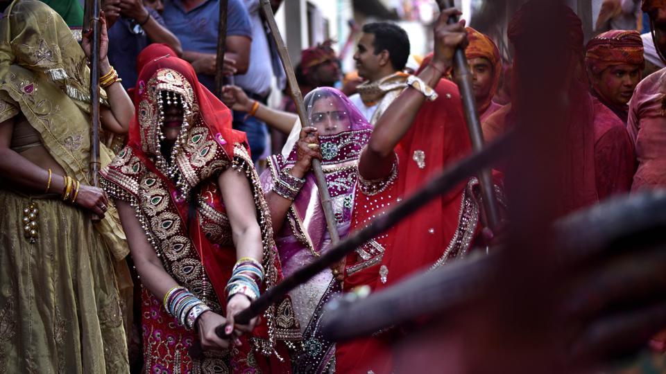 Women of Barsana dressed up in traditional attires beat the men of Nandagaon during the festival