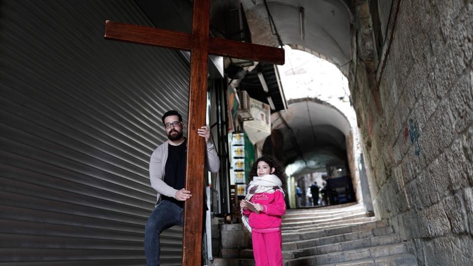 A Christian pilgrim and a child carry a wooden cross along the Via Dolorosa (Way of Suffering) in Jerusalem’s Old City. Churches observe the day with a service that normally takes place in the evening, where they remember Christ’s death with hymns, thanksgiving prayers, talk about the special significance that the day holds and observe the Lord’s Supper