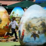A boy runs among two-metre-high Easter eggs painted in the traditional naive art style in Koprivnica, Croatia, April 9