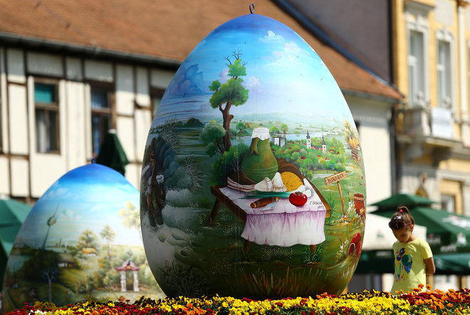 A child looks at a two-metre-high Easter eggs painted in the traditional naive art style in Koprivnica, Croatia, April 9