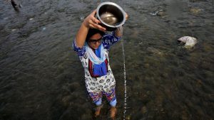 A devotee offers prayers to the Sun god in the waters of the River Tawi during the annual Hindu festival of Navratri in Jammu