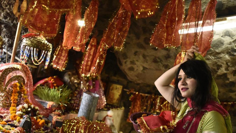 A devotees offer prayers inside a cave on Asthami, the eighth day of the festival of Navratri at Mata Mandir, in New Delhi