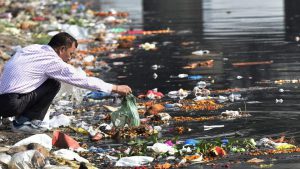 A man throws the puja offerings in Yamuna River at the end of Navratri festival in New Delhi. As the festival of Navratri ended, the rivers are once again in complete mess with several tonnes of flowers, polythene packets and other religious offerings floating on water
