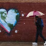 A man walks past a mural the day before Earth Day, in Philadelphia.