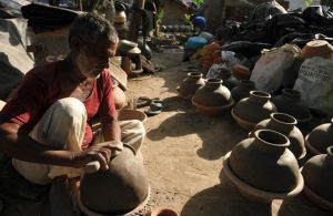 A potter working on earthen water coolers in Mansoorwal village on the outskirts of Kapurthala